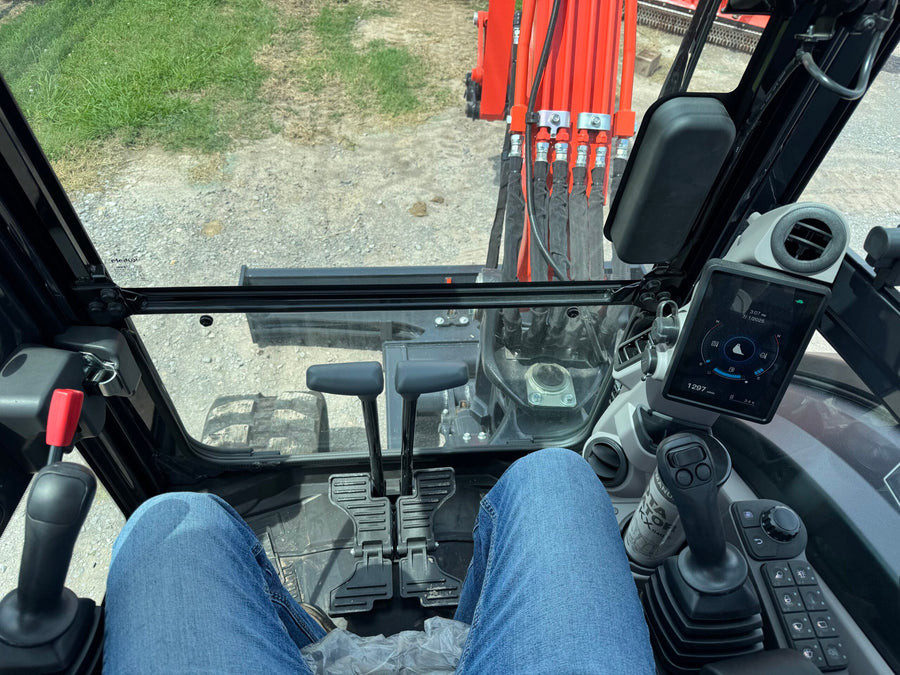 Kubota KX040-5 operator view from the cab with pilot joysticks and color display