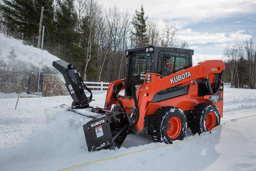 Kubota SSV75 skid steer with high-flow snow blower clearing a driveway