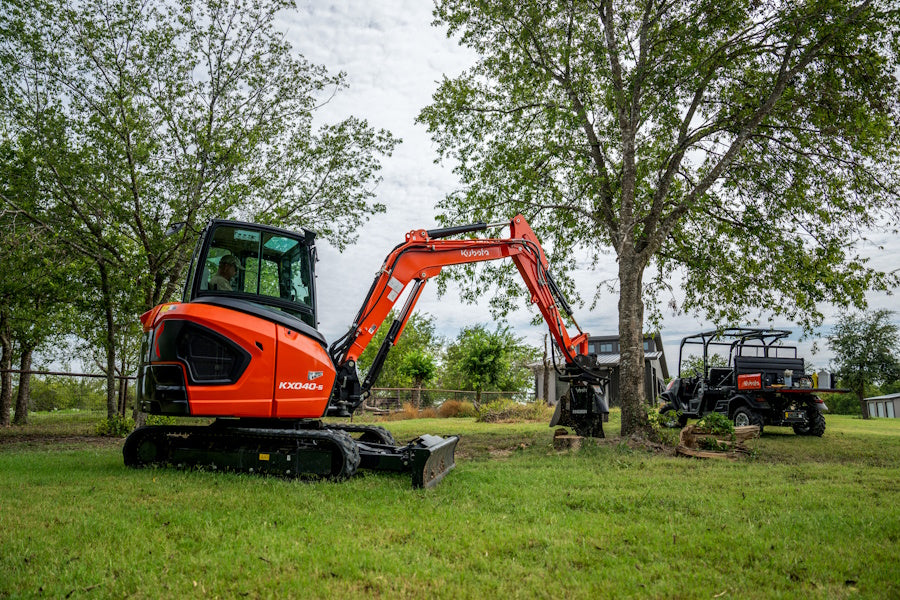 Kubota KX040-5 excavator working around trees on a rural property