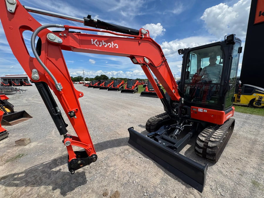 Kubota KX040-5 compact excavator with enclosed cab and dozer blade, front three-quarter view